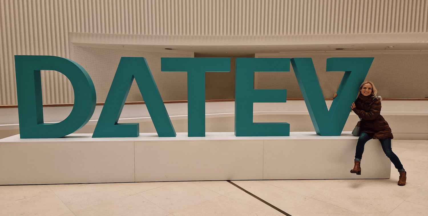 Sylvia umarmt ein Konstrukt mit dem Schriftzug "DATEV"